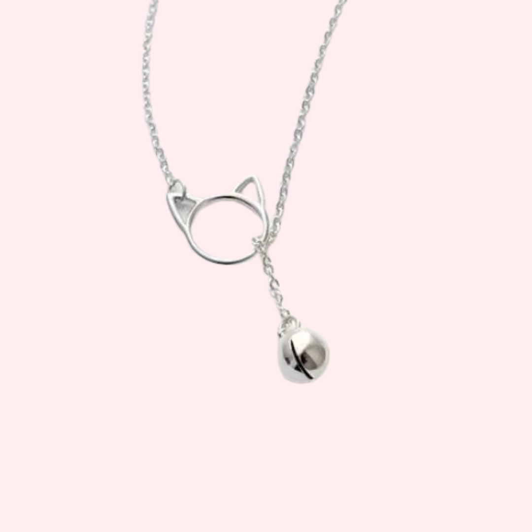 A tiny cat bell dangles through a delicate sterling silver cat head on a silver chain