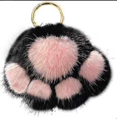Fuzzy black and pink paw-shaped keychain with a gold ring on a white background