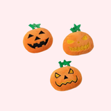 Orange jack-o’-lantern cat toys on a pink background